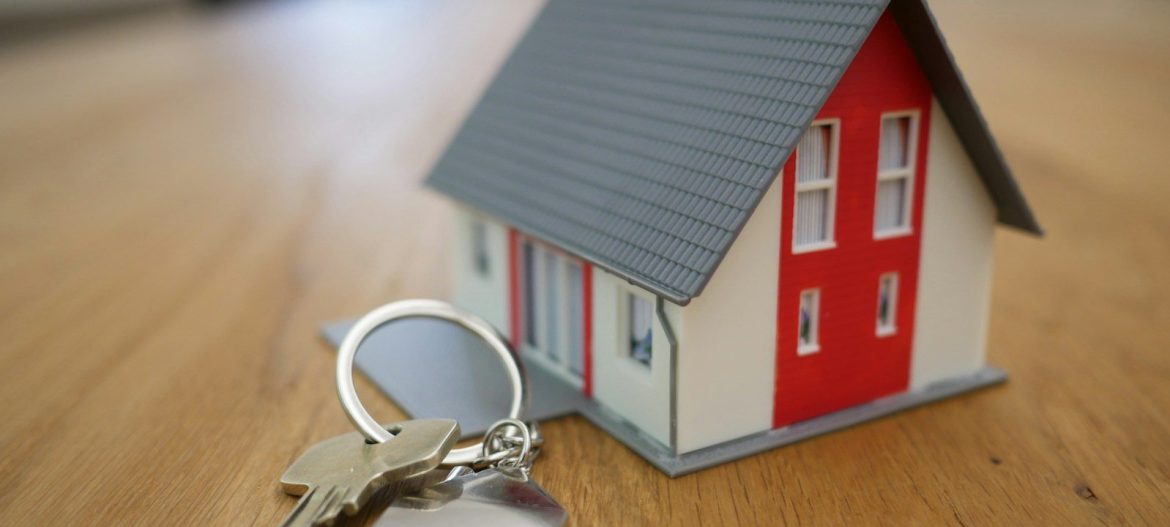 white and red wooden house miniature on brown table